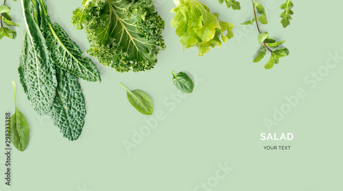 Creative layout made of kale, salad leaves, spinach, ruccola on green background. Flat lay. Food concept. Macro concept. photo