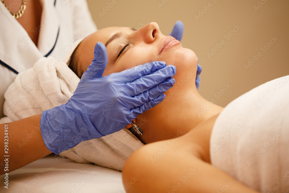 Close-up of woman having facial massage at the spa.