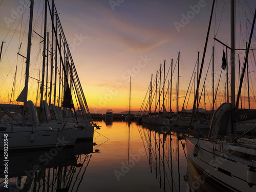 Fototapeta Naklejka Na Ścianę i Meble -  Nice sunset in quiet sea marina with sail boats silhouettes 
