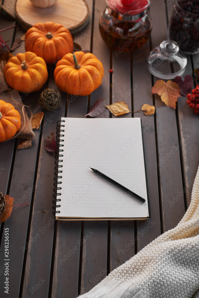 Planning to do list. Autumn mood composition on a wooden table with pumpkins, rowan and leaves. Open notepad with pen on grey wooden background Planning to do list. Autumn mood composition on a wooden table with pumpkins, rowan and leaves. Open notepad with pen on grey wooden background
