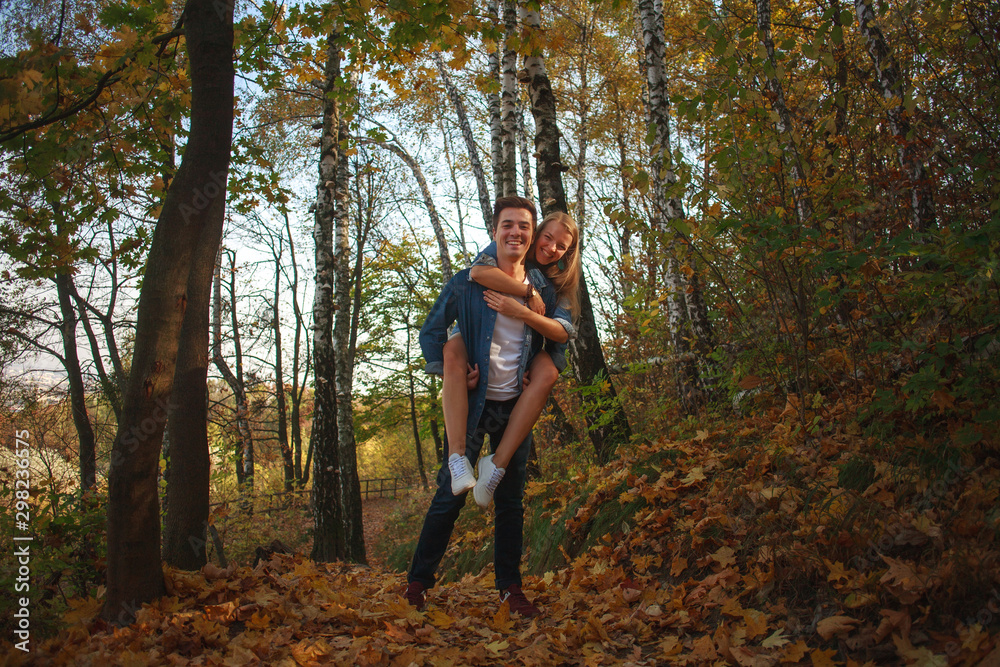 Happy young couple having fun walking in autumn forest park Happy young couple having fun walking in autumn forest park