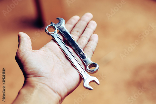 ็Hand is holding the two wrench