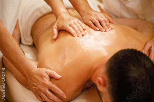 Close-up of four hands back massage.