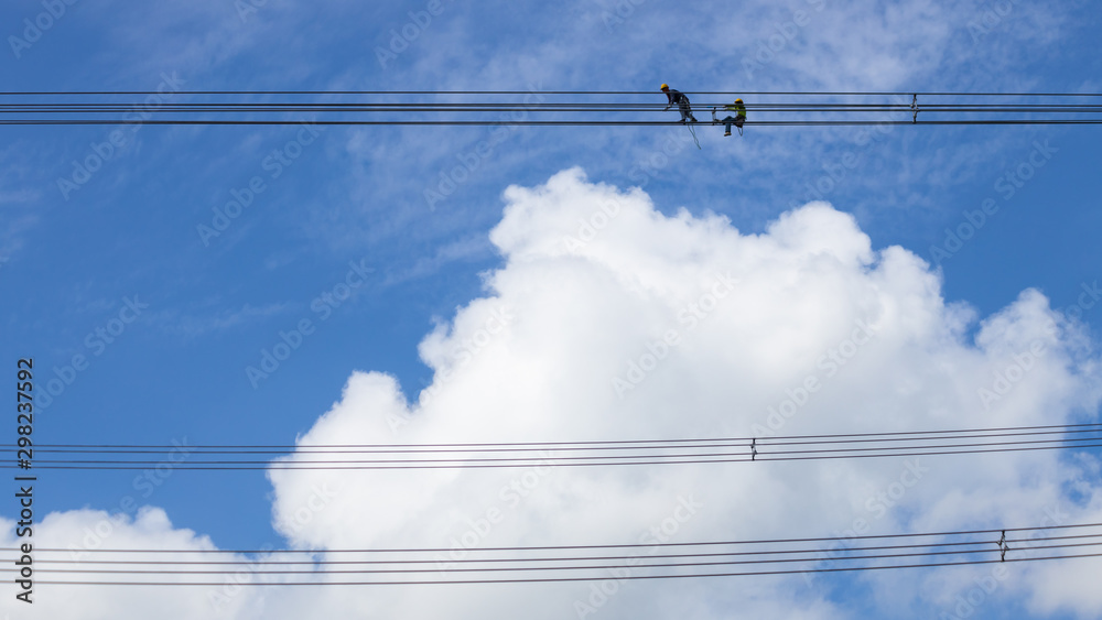 Fototapeta premium Electrician work installation of high voltage cable in high voltage safely and systematically over and blue sky background.
