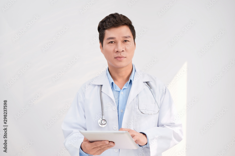 Asian smart doctor standing and holding tablet at hospital Asian smart doctor standing and holding tablet at hospital