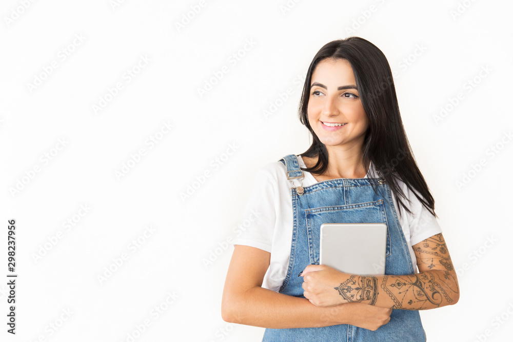 Smiling young woman with digital tablet. Beautiful young tattooed woman holding tablet computer and looking away isolated on white background. Technology concept Smiling young woman with digital tablet. Beautiful young tattooed woman holding tablet computer and looking away isolated on white background. Technology concept