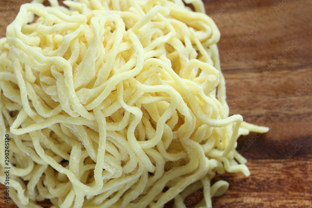 Chinese food ingredient, ramen noodles on wooden plate Chinese food ingredient, ramen noodles on wooden plate