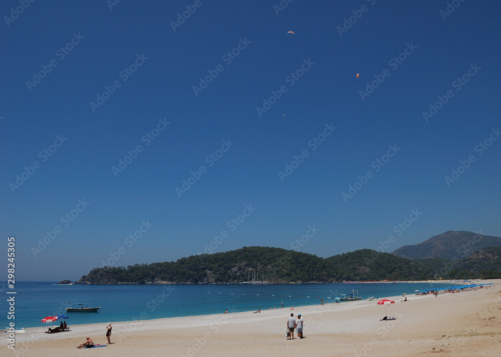 Paraglides over Belceğiz beach in Ölüdeniz, Turkey