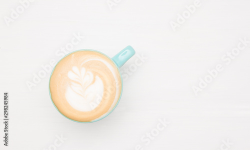 Homemade cappuccino coffee latte art on white wooden background. Copy-space for your text