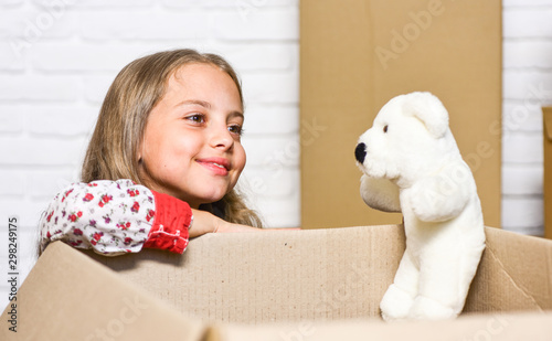 Fototapeta Naklejka Na Ścianę i Meble -  play with me. Cardboard boxes - moving to new house. happy child cardboard box. happy little girl with toy. repair of room. new apartment. purchase of new habitation