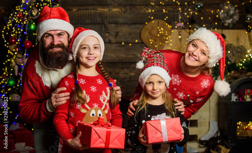 Parents and children opening christmas gifts. Christmas tradition. Boxing day. Happy holidays. Father bearded man and mother with cute daughters christmas tree background. Spend time with your family