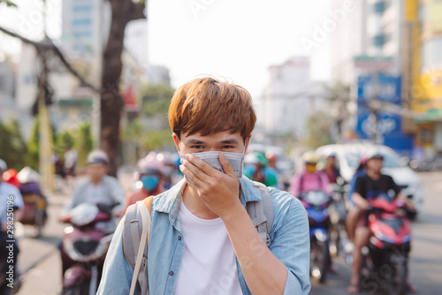 Asian man in the street wearing protective masks., Sick man with flu wearing mask and blowing nose into napkin as epidemic flu concept on the street.