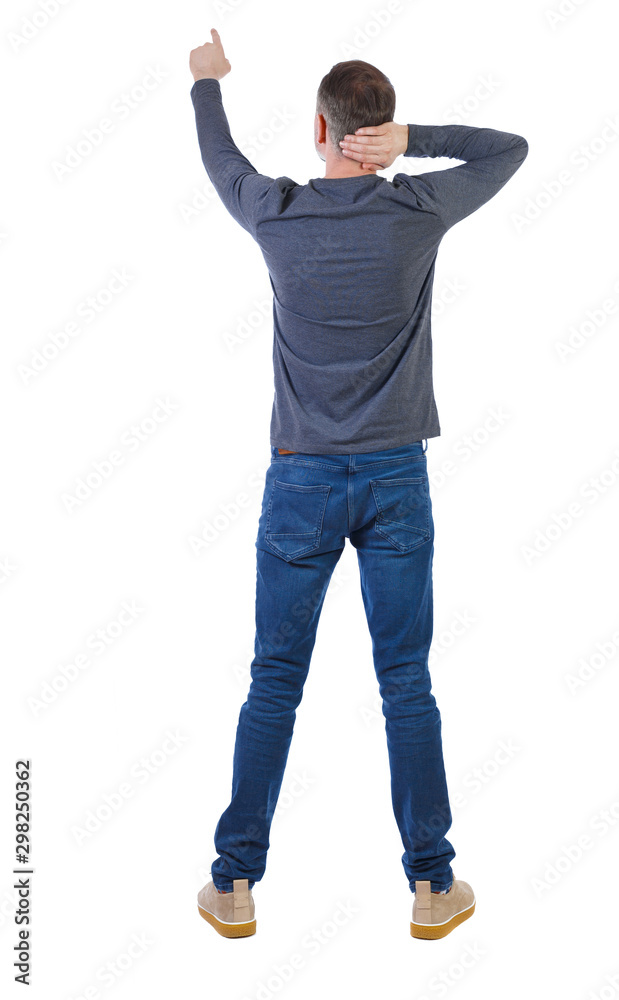 Back view of a man in jeans points his hand upwards. Back view of a man in jeans points his hand upwards.