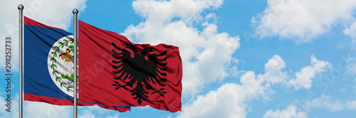 Belize and Albania flag waving in the wind against white cloudy blue sky together. Diplomacy concept, international relations.
