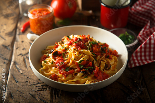 Homemade pasta with tomato sauce and olives