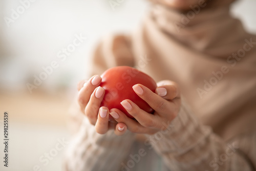 Close up of woman holding tomato in her hands