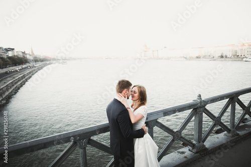 Young wedding couple, beautiful bride with groom portrait on the bridge, summer nature outdoor