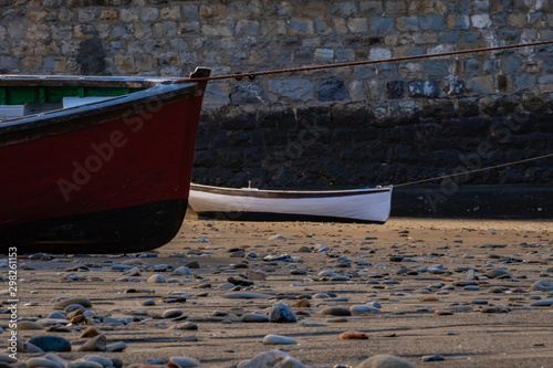 Two boats stranded on a beach with stones