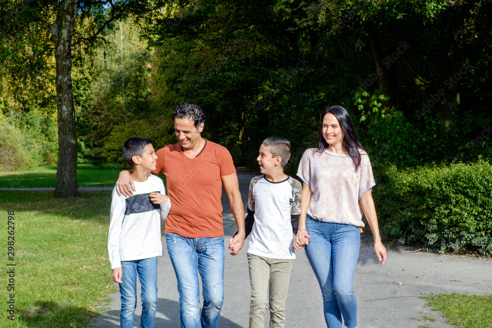 walking family with two children in park walking family with two children in park