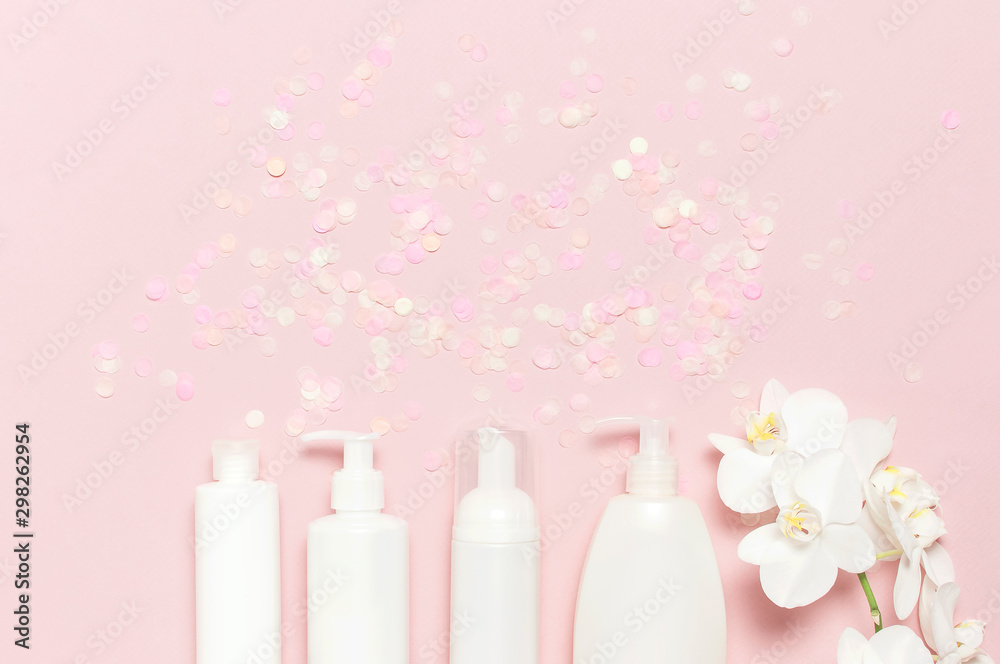 Cosmetics SPA branding mock-up Natural organic beauty product. Flat lay White cosmetic bottle containers festive confetti White Phalaenopsis orchid flowers on pink background top view Cosmetics SPA branding mock-up Natural organic beauty product. Flat lay White cosmetic bottle containers festive confetti White Phalaenopsis orchid flowers on pink background top view