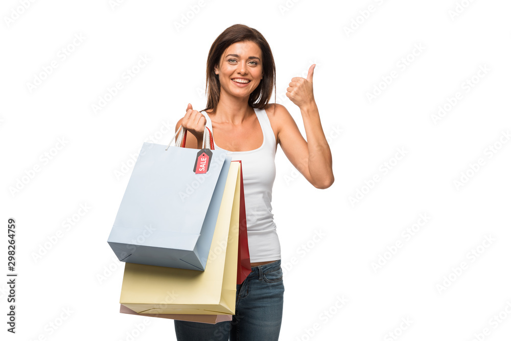 beautiful girl holding shopping bags with sale signs while showing thumb up, isolated on white beautiful girl holding shopping bags with sale signs while showing thumb up, isolated on white