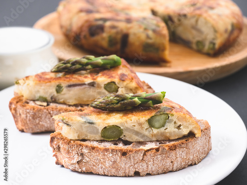Vegetable omelette with asparagus on a sourdough bread slice. Asparagus tortilla on toast.  