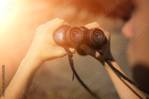 Binoculars in hand. Look through the binoculars. Silhouette of a businessman with binoculars to look for opportunities for success. fresh air