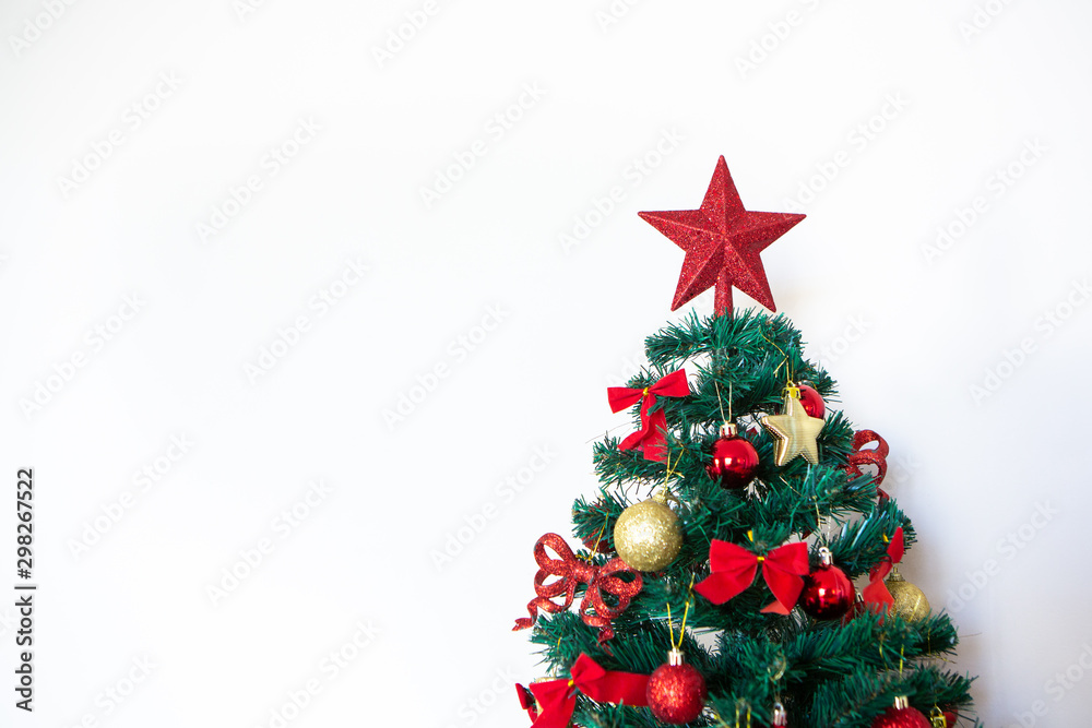Red Christmas star on top of Christmas tree decorated with balls and bows isolated on white background. Concept of merry christmas, holidays, happy new year, gifts, happiness and celebration. Red Christmas star on top of Christmas tree decorated with balls and bows isolated on white background. Concept of merry christmas, holidays, happy new year, gifts, happiness and celebration.