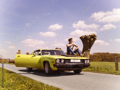 Photography young attractive man in his oldschool us muscle car
