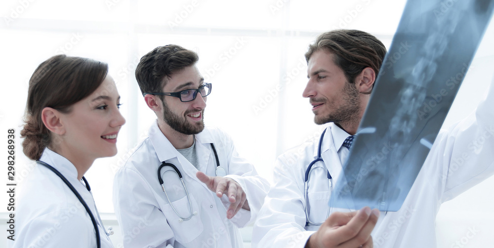 Fototapeta premium Three confident doctors examine an x-ray
