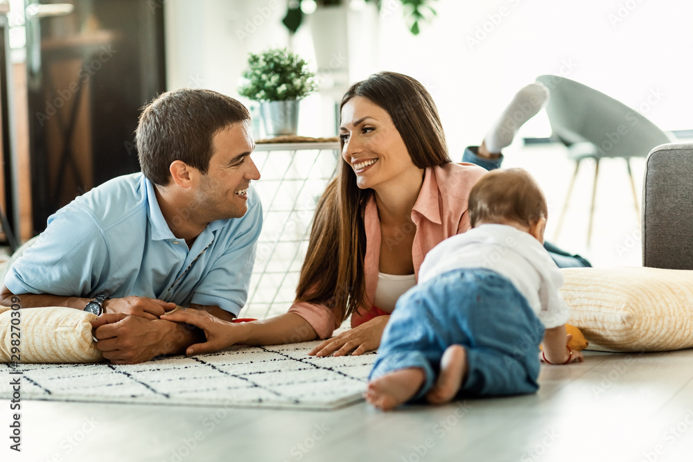 Happy parents talking while enjoying with their small boy at home.