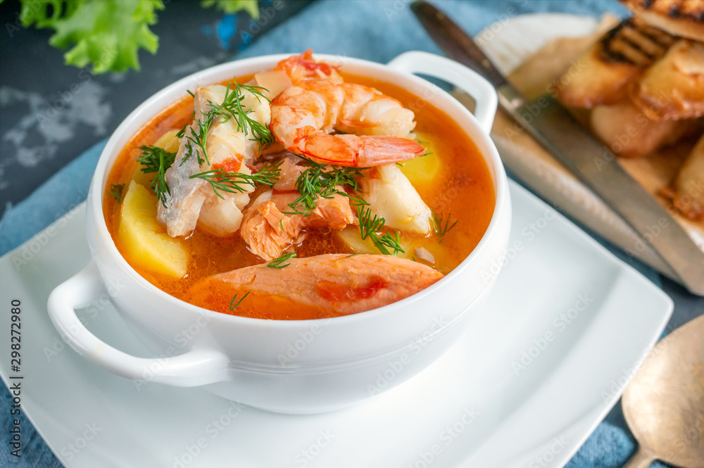 Diet soup of seafood and fish of different varieties in a white soup plate. Close up Diet soup of seafood and fish of different varieties in a white soup plate. Close up