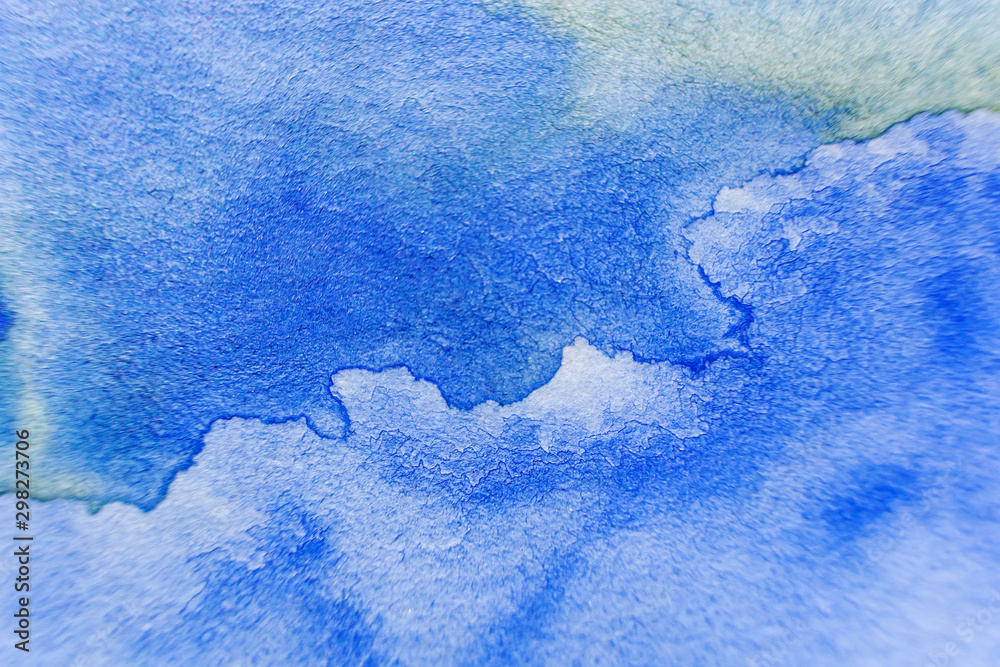 A stain of blue watercolor paint on paper. Macro photo. Background minimalistic vibrant image. The concept of drawing.