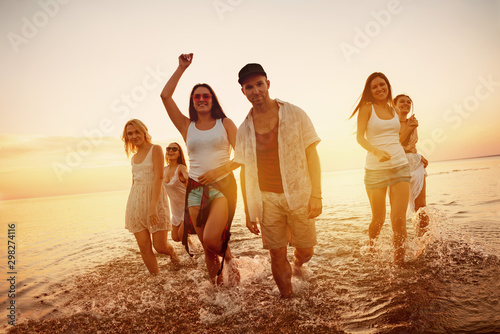 Group of young friends at sunset beach party