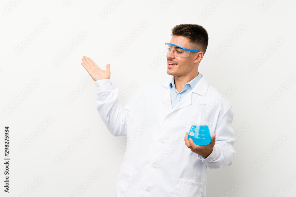 Young scientific holding laboratory flask over isolated background with surprise facial expression Young scientific holding laboratory flask over isolated background with surprise facial expression