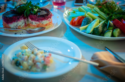 Traditional new year celebration meals of russian table herring and Olivier salads are on plates in restaurant © Yuriy