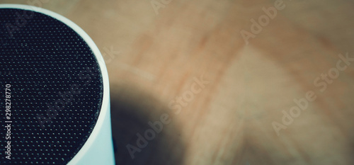 Closeup of an auido speaker on a wooden table.  Blurred background as copy space. photo