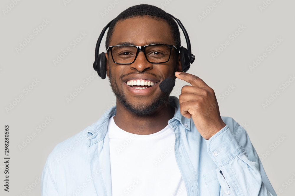 © fizkes - Head shot smiling African American support service operator in headphones