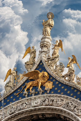 Venice, detail of the Basilica of San Marco with the statue of St Mark the evangelist, golden winged lion and angels. UNESCO world heritage site, Veneto, Italy, Europe