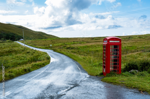 Rote Telefonzelle neben einer Landstraße auf der Isle auf Skye in den schottischen Highlands