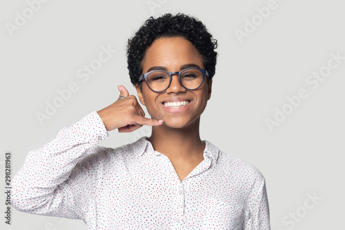 Head shot smiling African American woman showing call me gesture