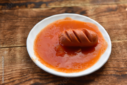 hot sausages with cuts in tomato sauce