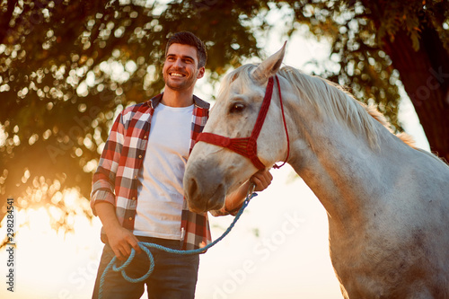 Young man and horse. Smiling man have a hobby time, riding.