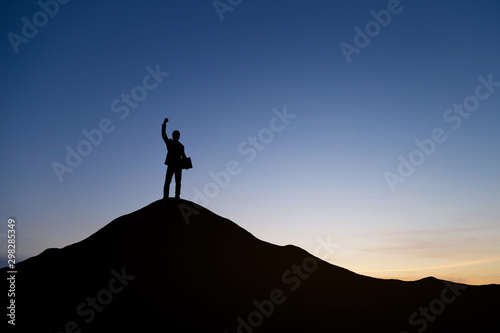 Silhouette of businessman raising his hand to celebrate success on top of mountain, White background.