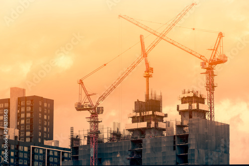 Photography Crane and construction site working on building complex at sunset, developing ci