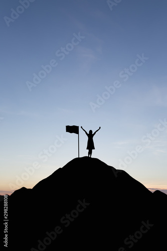 Silhouette of people and flag on top mountain, sky and sun light background. Business success and goal concept.