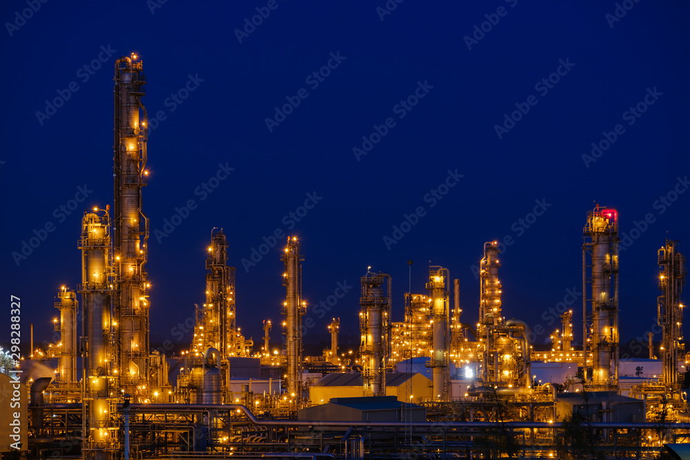 Glitter lighting of petroleum industrial with gas distillation tower on blue twilight sky background