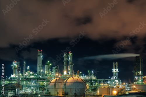 Oil and gas refinery plant or petrochemical industry on night sky background  Factory at night   Gas storage sphere tank in petroleum industrial with columns tower and smoke stacks