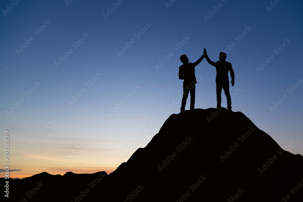 Silhouette of people are celebrating success at the top of the mountain, sky and sun light background. Team business concept. Silhouette of people are celebrating success at the top of the mountain, sky and sun light background. Team business concept.