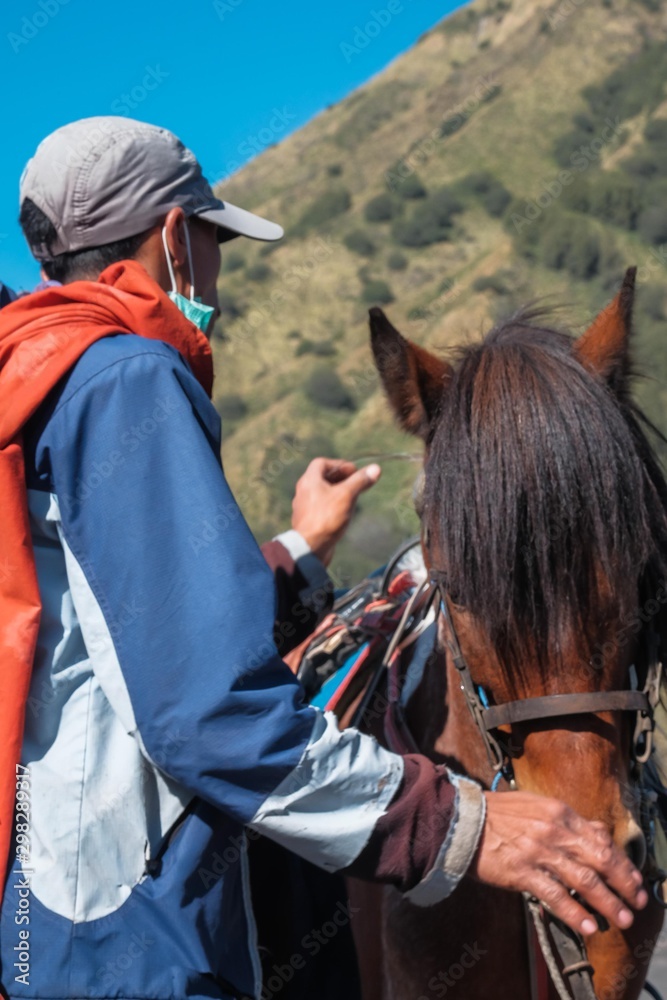 Obraz premium Mount Bromo Indonesia - Jun 13, 2016 : Young Tenggerese man work as horseman waiting for tourist at Mount Bromo one of an active volcano that most visited by tourist in East Java Indonesia